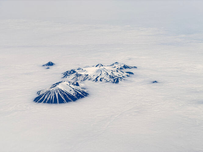 Atka Island 火山群从云海中露出积雪山顶