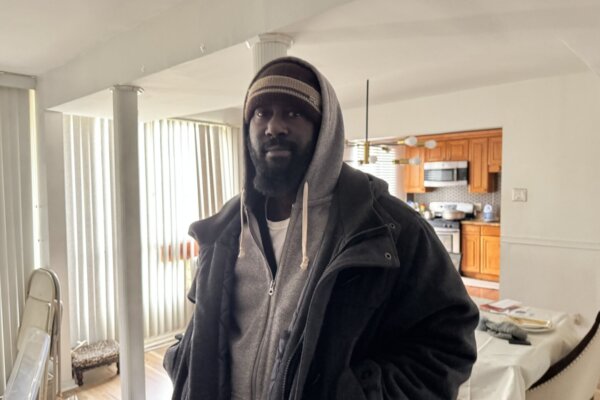 一名男子身穿厚重的冬装,站在公寓单元内。