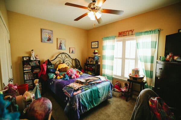 A colorful bedroom with stuffed animals, Disney princess toys and décor, and letters spelling MISTY over a window.